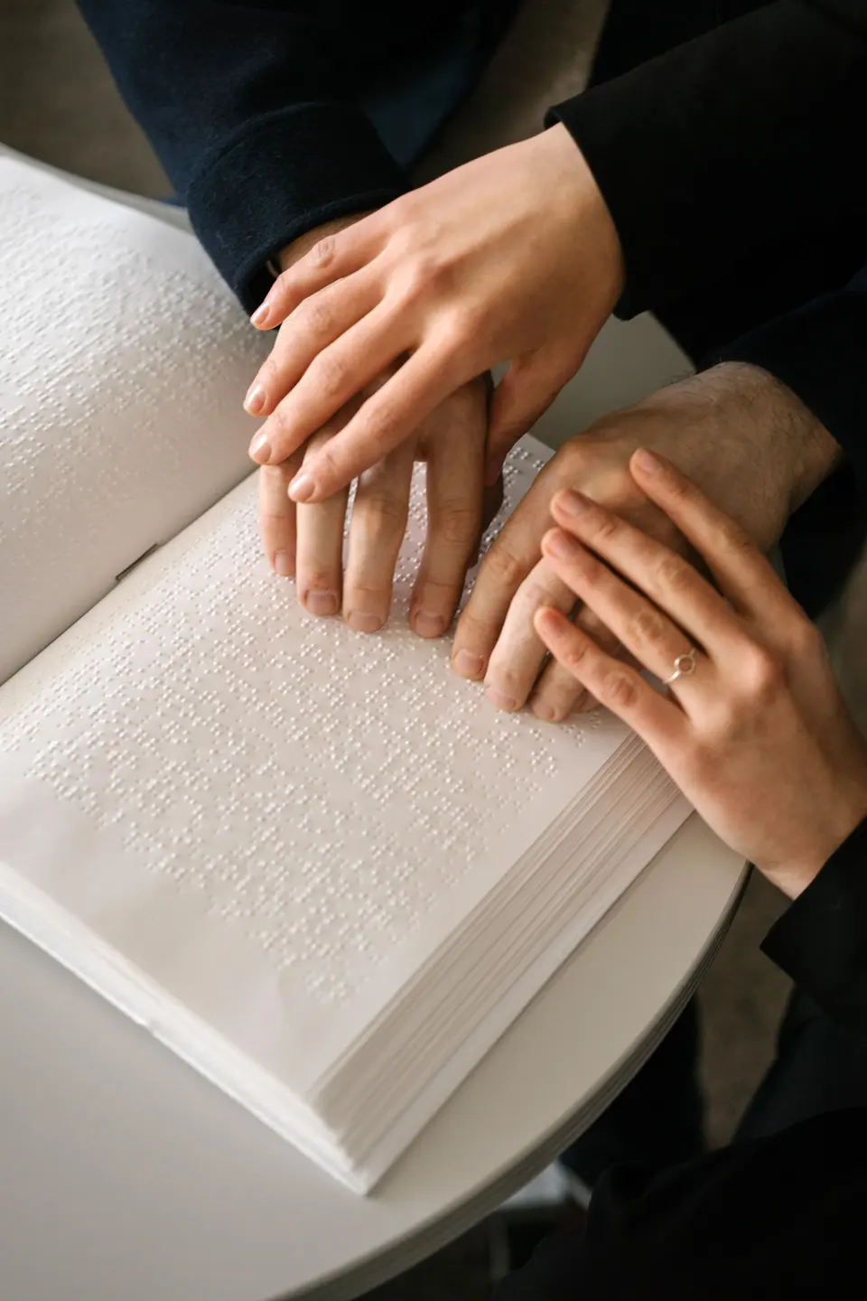 Hands reading a braille book