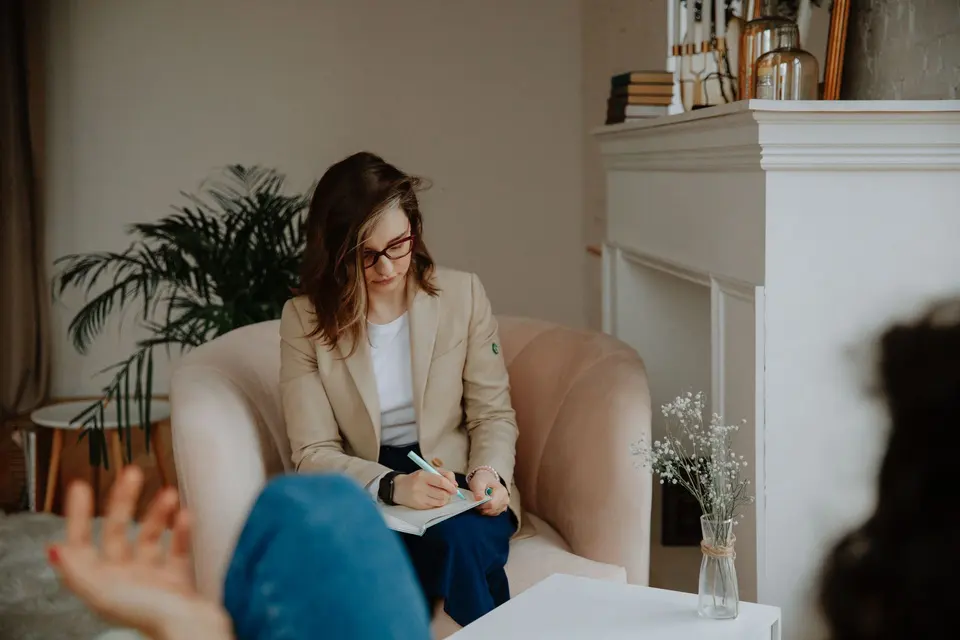 Psychologist taking notes in an armchair during a session