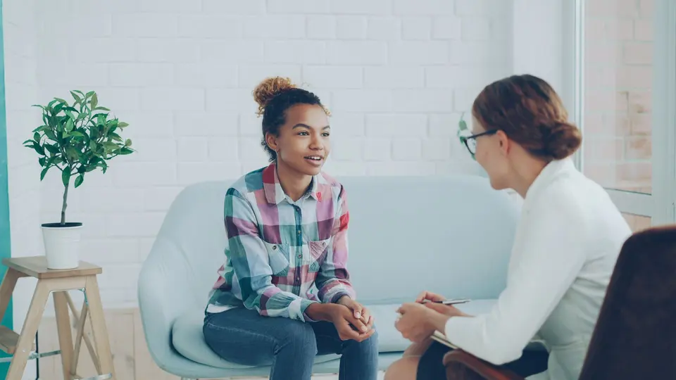 Psychologist listening to a teenage client during a session